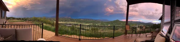 a view of a balcony with floor to ceiling windows and wooden fence