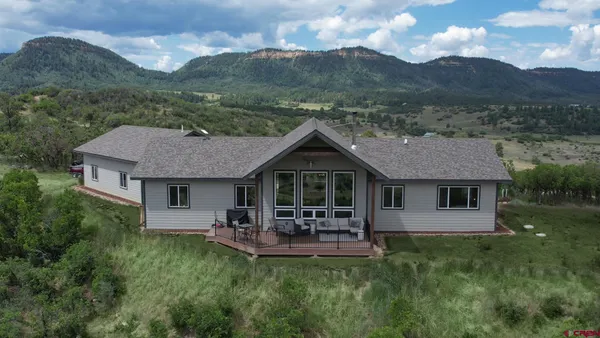 a living room with furniture a flat screen tv and a large window