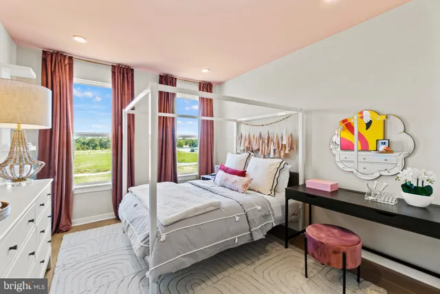 a bedroom with a bed dresser and painting on the wall