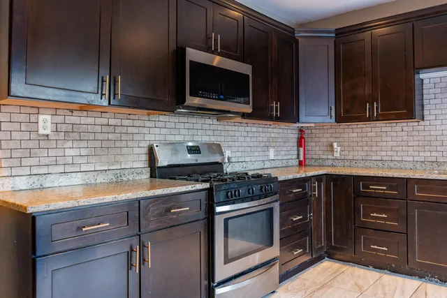a kitchen with stainless steel appliances a stove microwave and cabinets