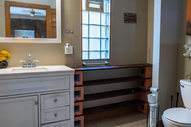 a bathroom with a sink a toilet and mirror