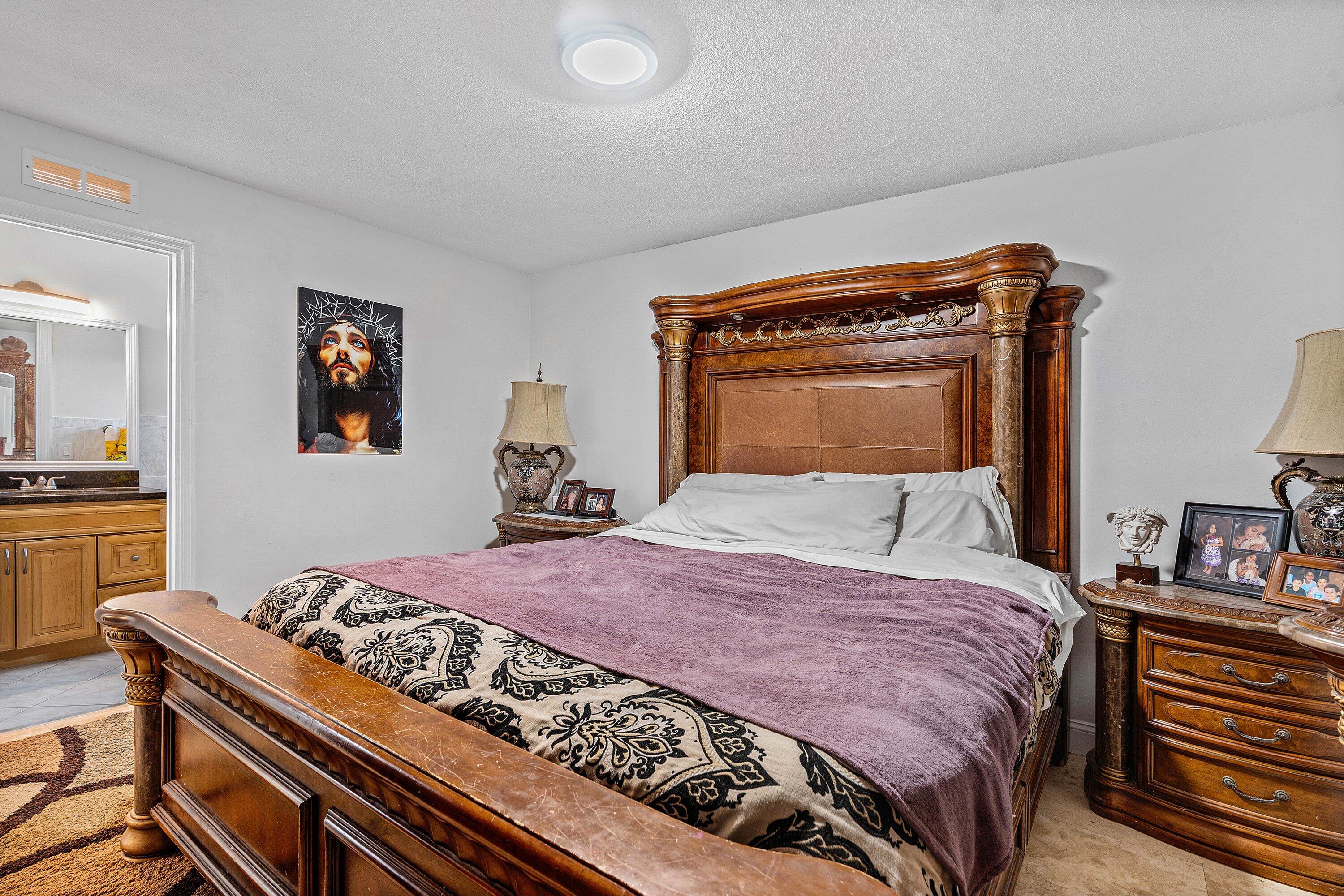 22207 Southwest 65th Terrace Boca Raton, FL 33428 - Photo 18 of 27 a bedroom with a bed and a chandelier