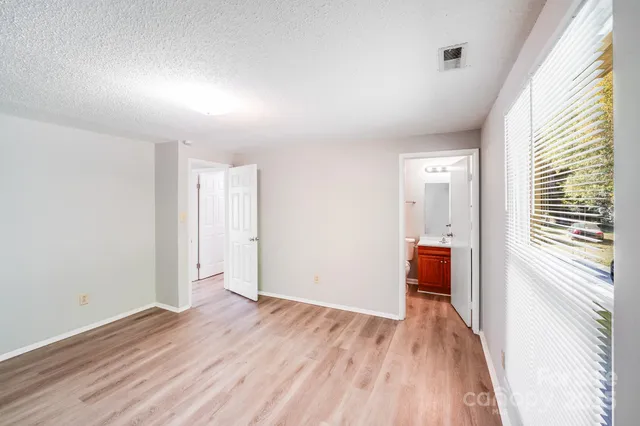 a view of hallway with a large window and wooden floor