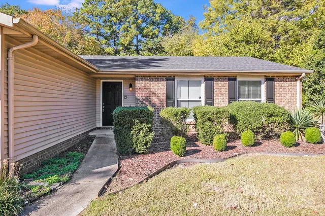 a front view of a house with a yard and potted plants