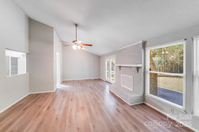 a view of a kitchen with wooden floor and a ceiling fan