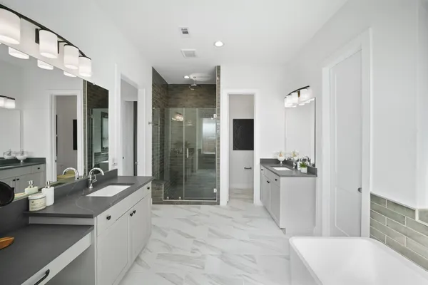 a large bathroom with a tub sink shower and mirror