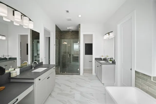 a large bathroom with a tub sink shower and mirror
