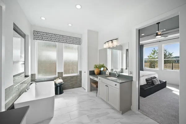 a large bathroom with a double vanity sink a large mirror and a bathtub