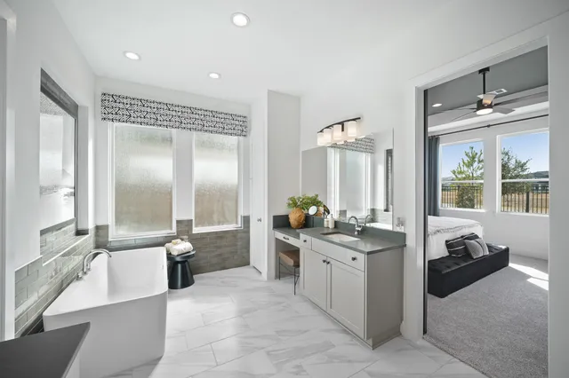 a large bathroom with a double vanity sink a large mirror and a bathtub