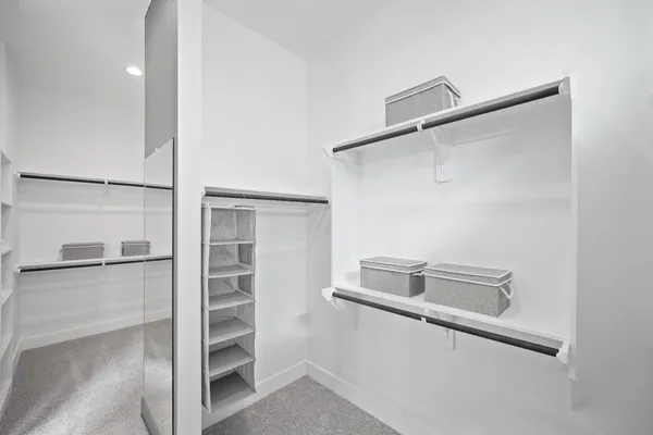 a view of walk in closet with empty racks