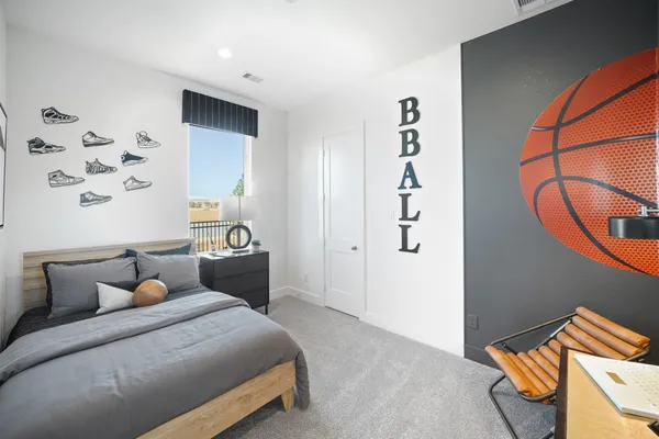 a bedroom with a bed and a lamp with the dresser