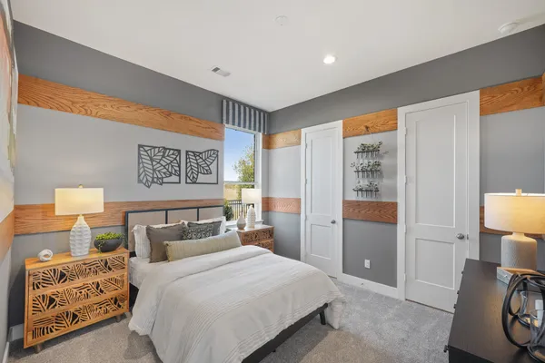 a bedroom with a bed and a lamp with the dresser