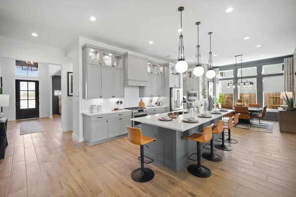 a room with stainless steel appliances kitchen island a table and chairs in it