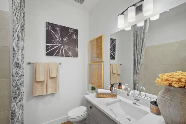 a bathroom with a sink a toilet and mirror