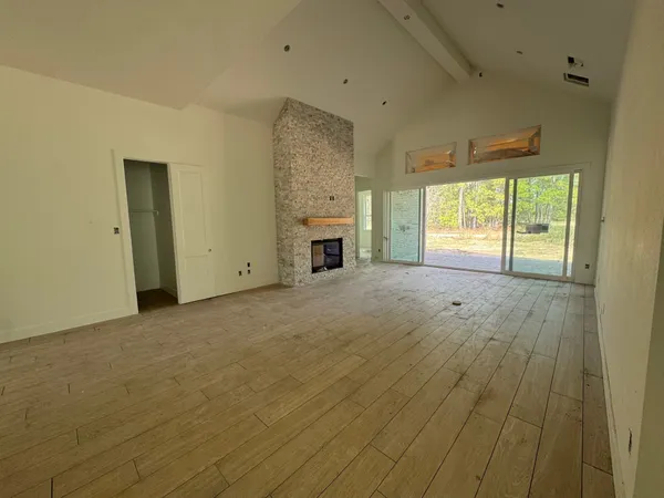 a view of empty room with a fireplace and windows