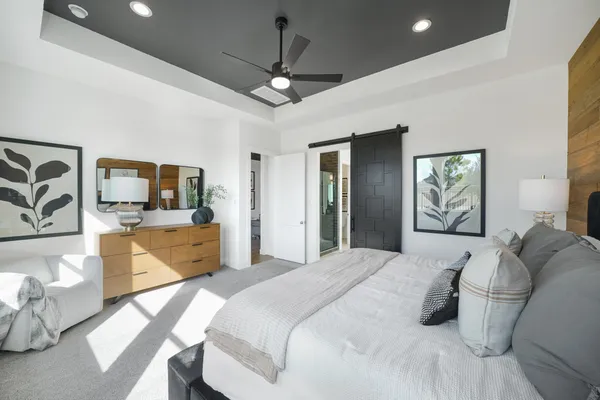 a bedroom with a large bed and a chandelier