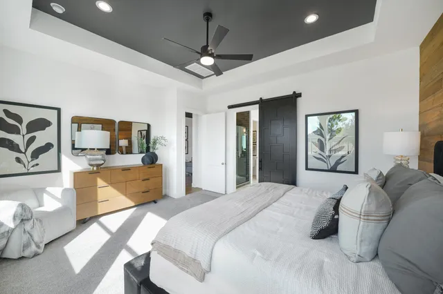 a bedroom with a large bed and a chandelier
