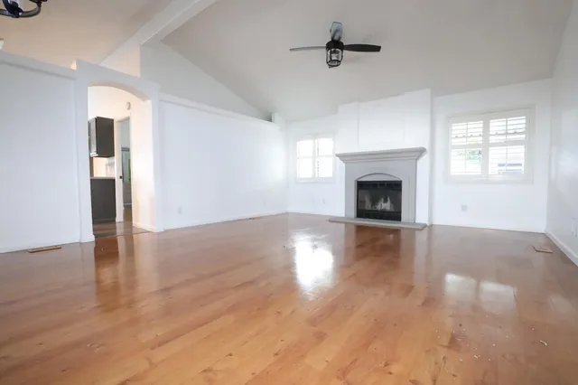 a view of empty room with wooden floor and fireplace