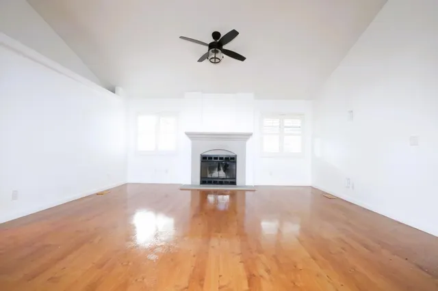 a view of an empty room with a fireplace and a window