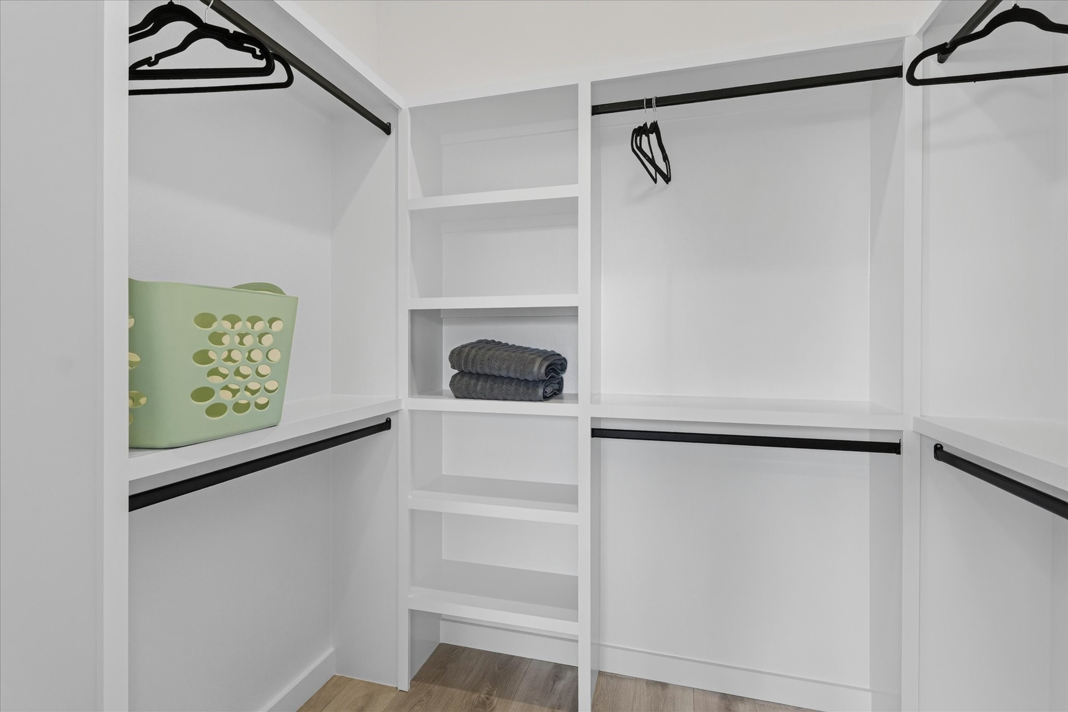 2000 Riverside Farms Road, Unit 8101 Austin, TX 78741 - Photo 25 of 41 This spacious walk-in closet features white shelving and hanging rods, providing ample storage and organization options. The light wood flooring adds a warm touch.