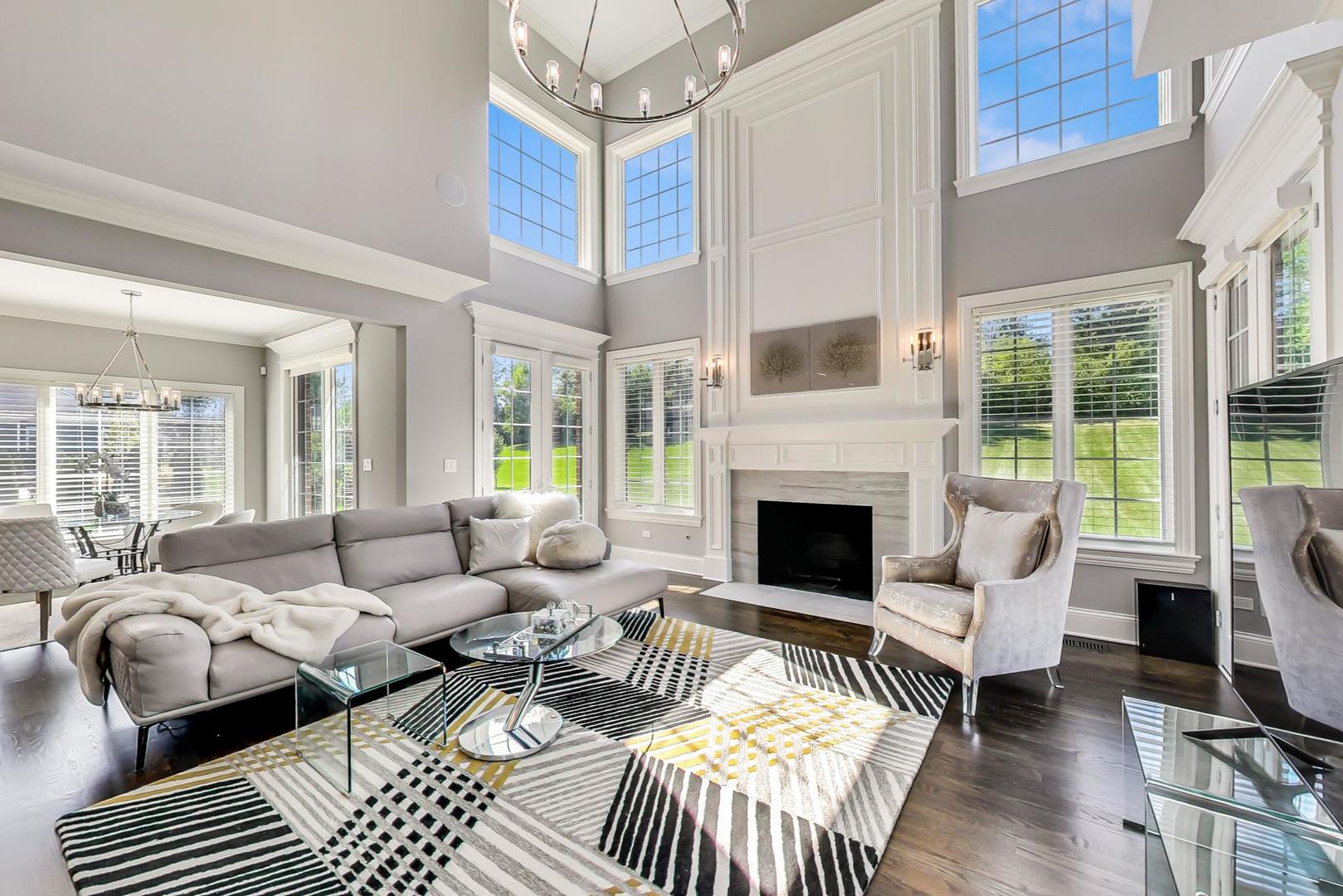 8310 Waterview Drive Burr Ridge, IL 60527 - Photo 9 of 35 a living room with furniture a fireplace and a floor to ceiling window