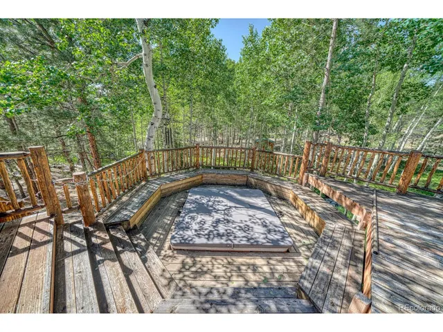 a view of a patio with table and chairs with wooden floor and fence