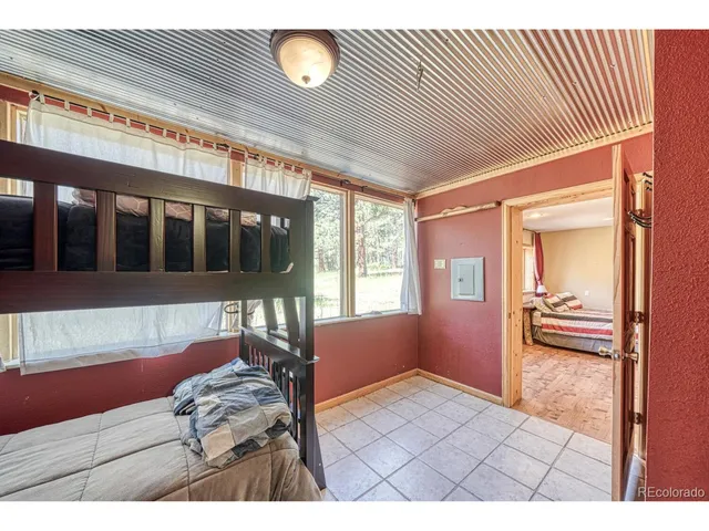 a living room with a bed furniture and a flat screen tv