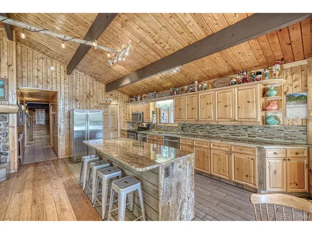 a kitchen with stainless steel appliances granite countertop a sink dishwasher and cabinets with wooden floor