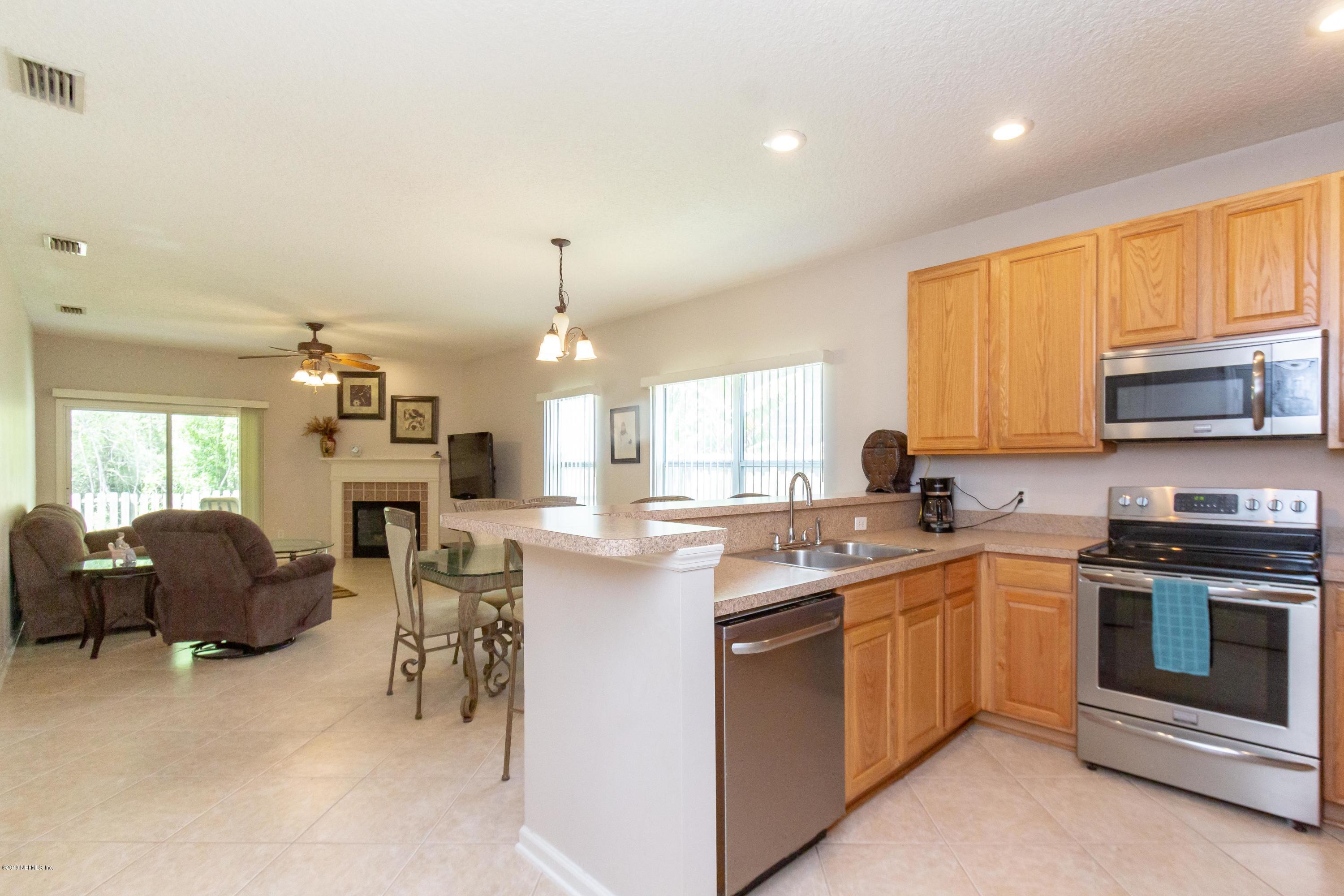 321 Stonehurst Parkway St. Augustine, FL 32092 - Photo 18 of 60 a kitchen with stainless steel appliances granite countertop a stove top oven a sink dishwasher a dining table and chairs with wooden floor