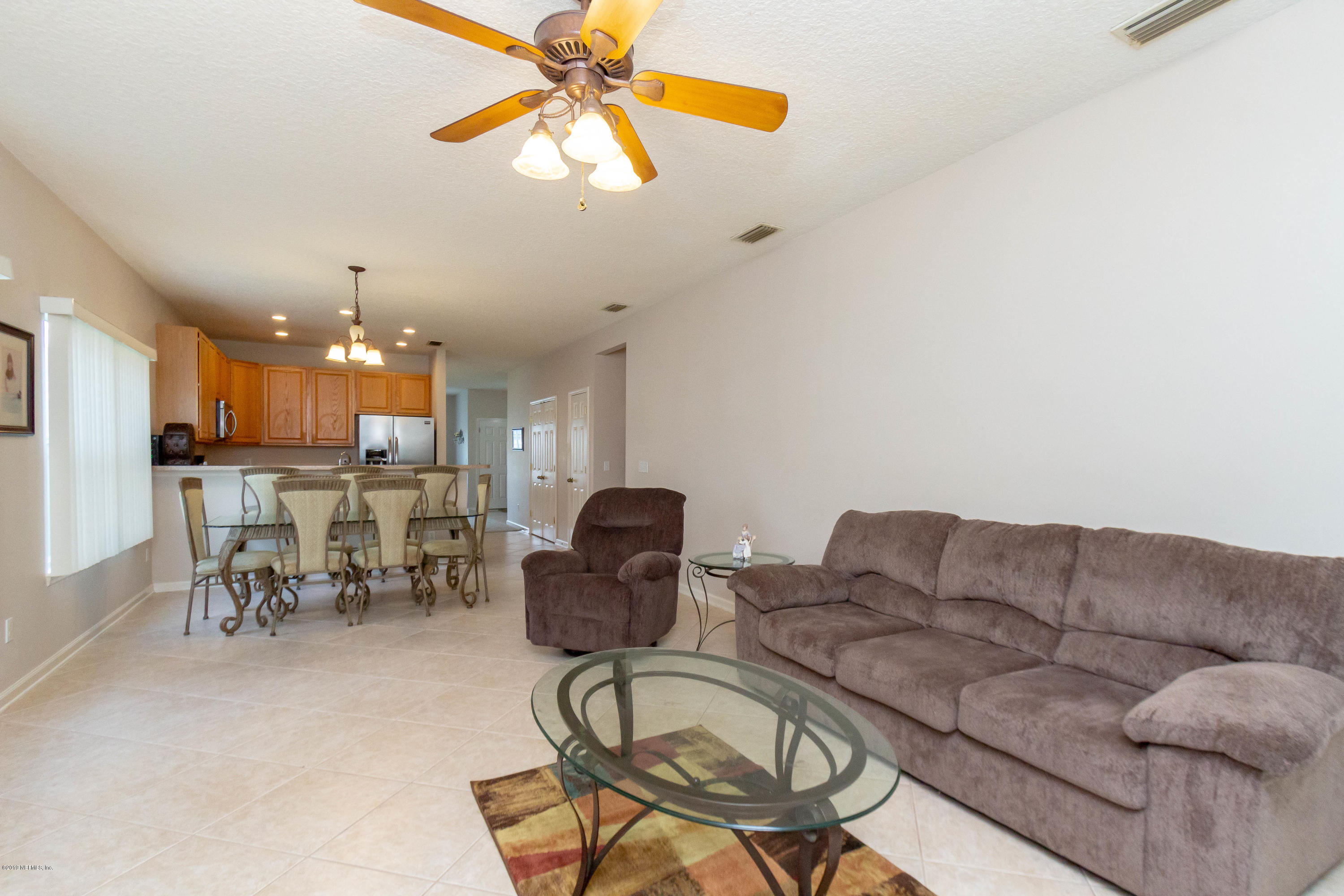 321 Stonehurst Parkway St. Augustine, FL 32092 - Photo 22 of 60 a living room with furniture a dining table and a chandelier