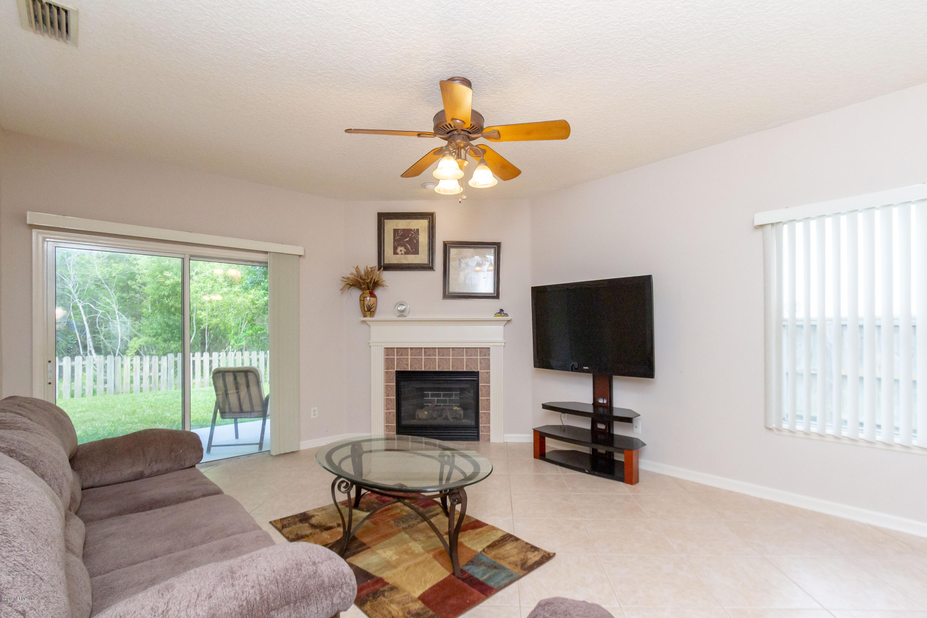 321 Stonehurst Parkway St. Augustine, FL 32092 - Photo 24 of 60 a living room with furniture a fireplace and a flat screen tv