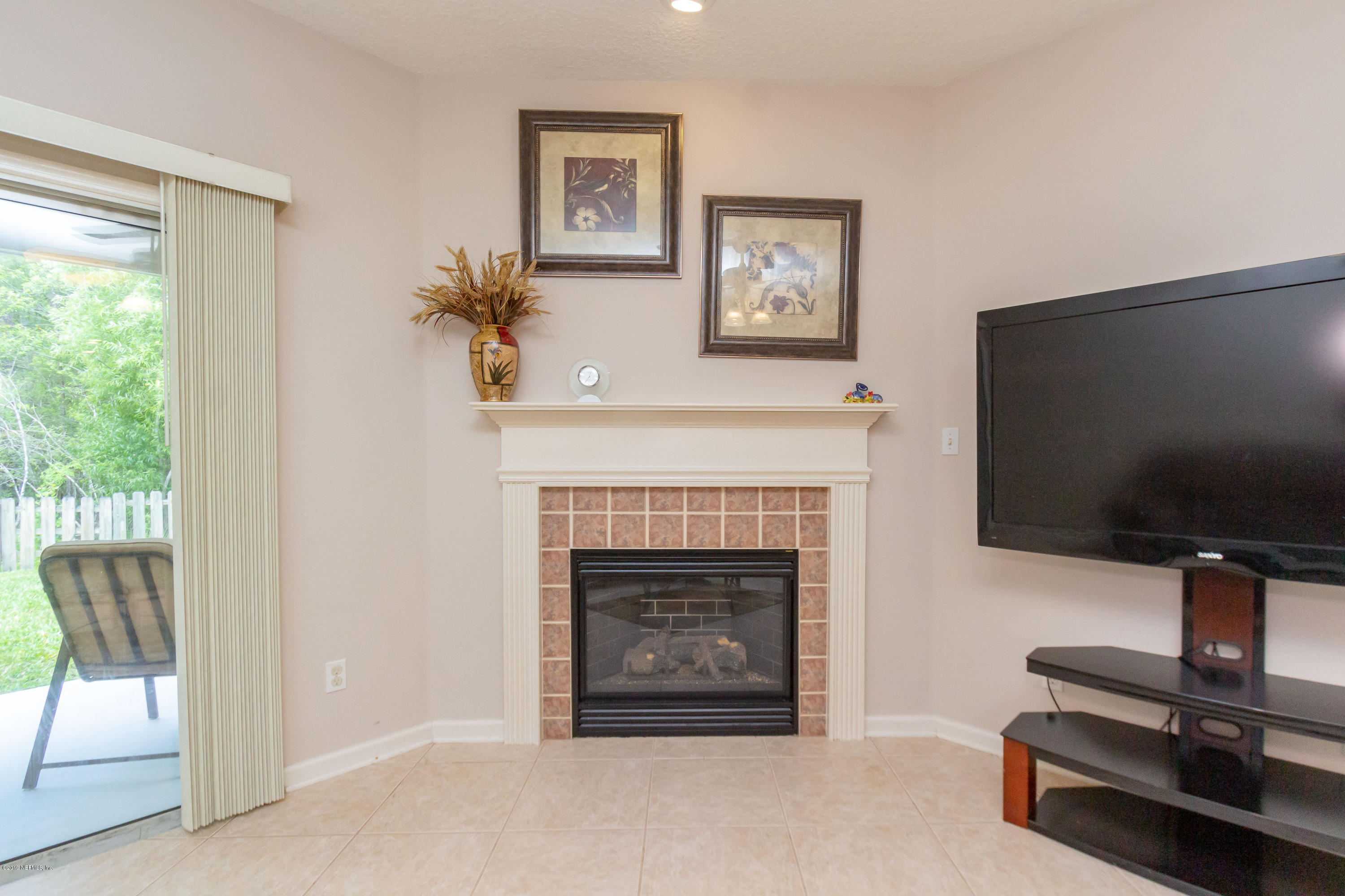 321 Stonehurst Parkway St. Augustine, FL 32092 - Photo 25 of 60 a living room with furniture a flat screen tv and a fireplace