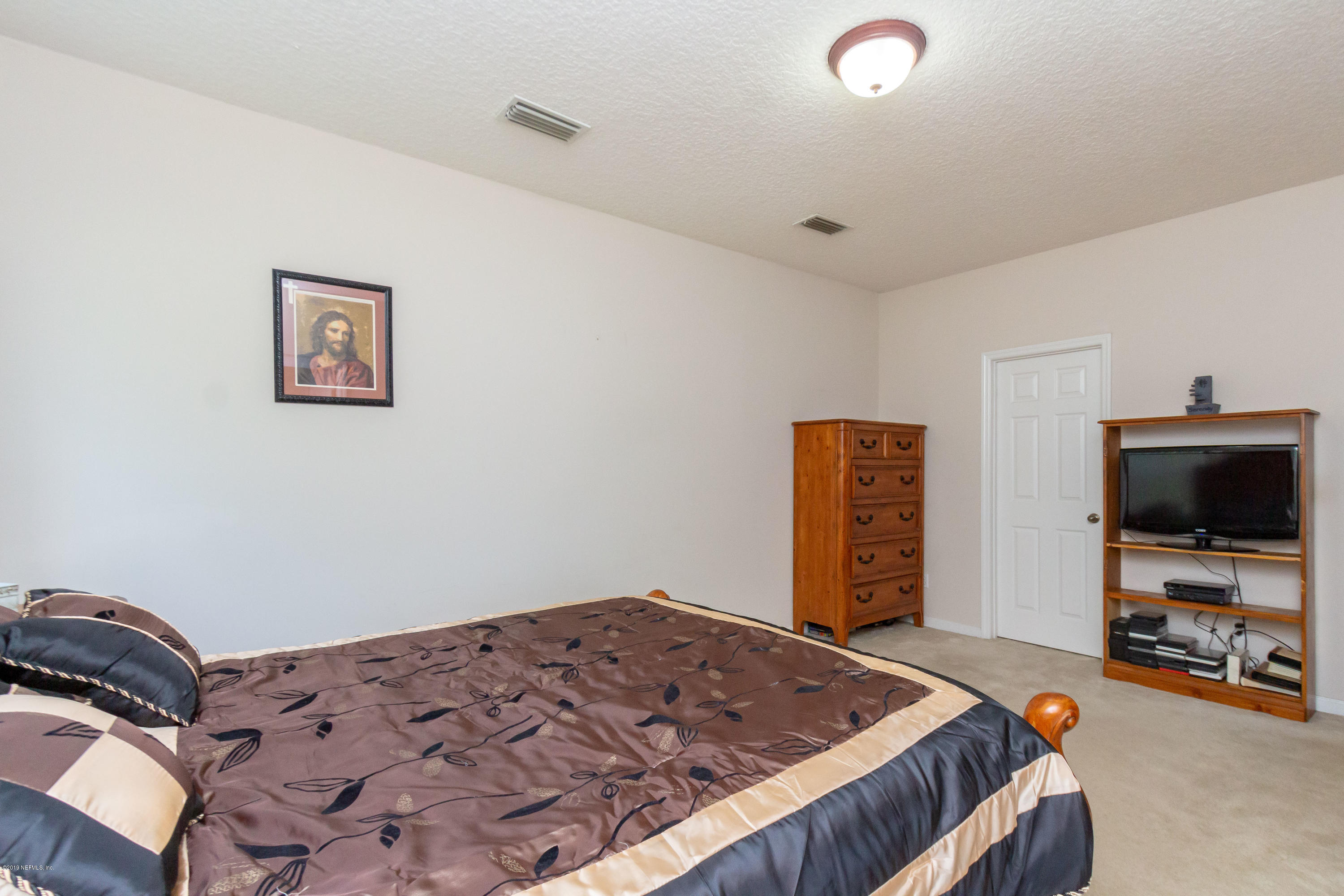 321 Stonehurst Parkway St. Augustine, FL 32092 - Photo 28 of 60 a bedroom with a bed and a flat screen tv
