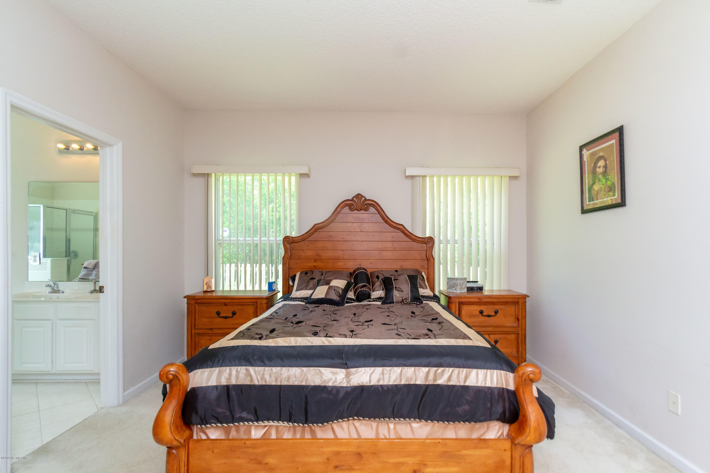 321 Stonehurst Parkway St. Augustine, FL 32092 - Photo 29 of 60 a bed sitting in a bedroom next to a window