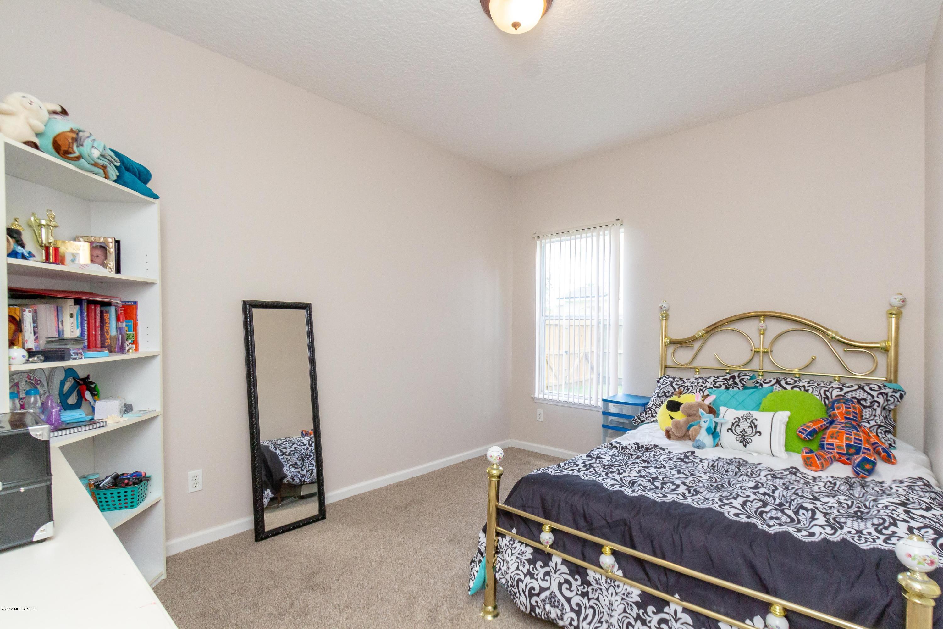 321 Stonehurst Parkway St. Augustine, FL 32092 - Photo 33 of 60 a bedroom with a bed a dresser and a book shelf