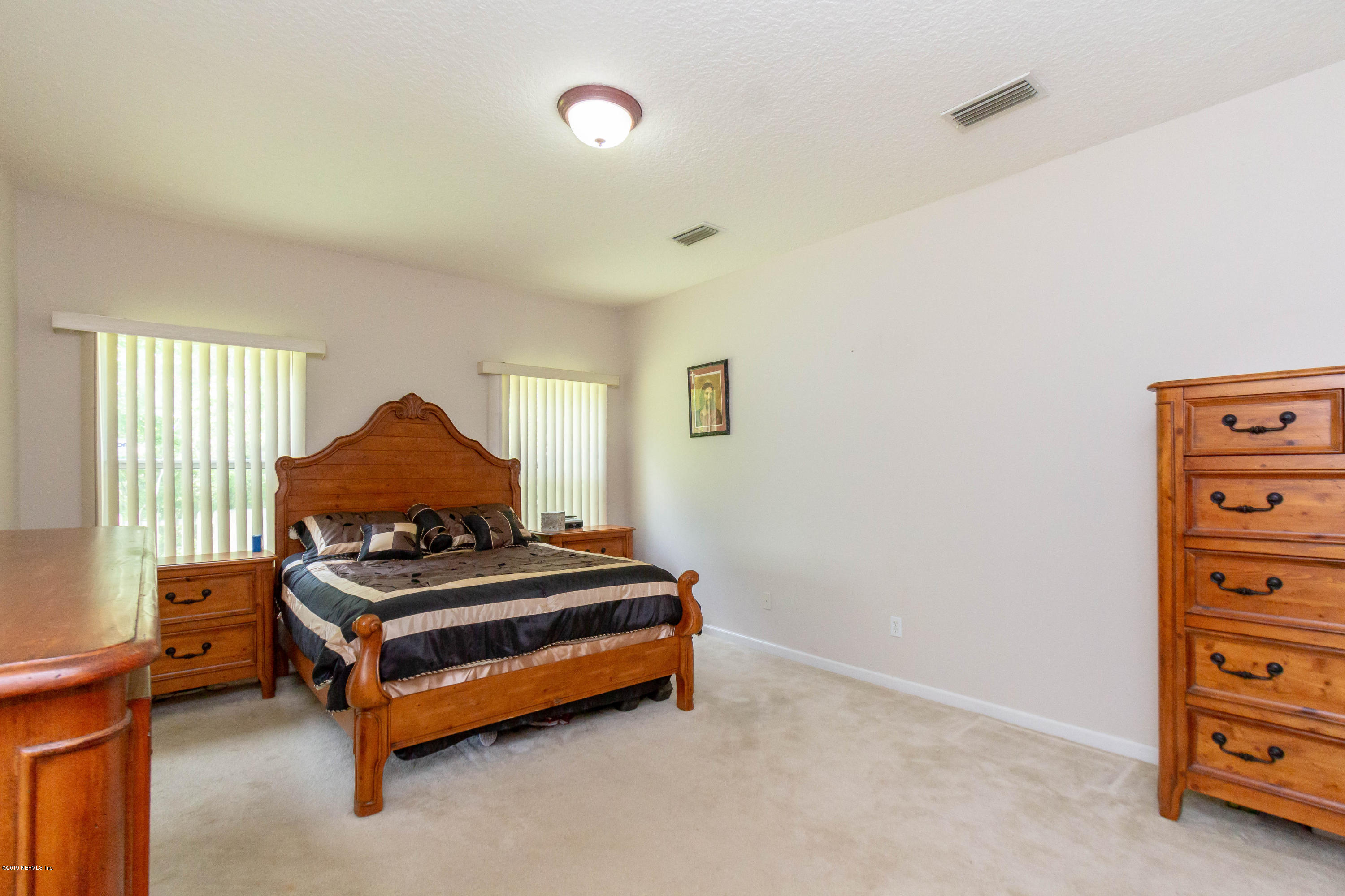 321 Stonehurst Parkway St. Augustine, FL 32092 - Photo 4 of 60 a bedroom with a bed and a chair