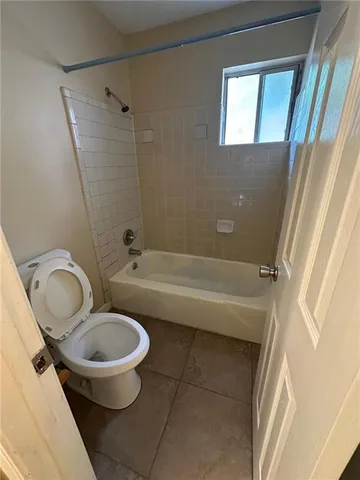 a bathroom with a granite countertop bathtub sink and toilet