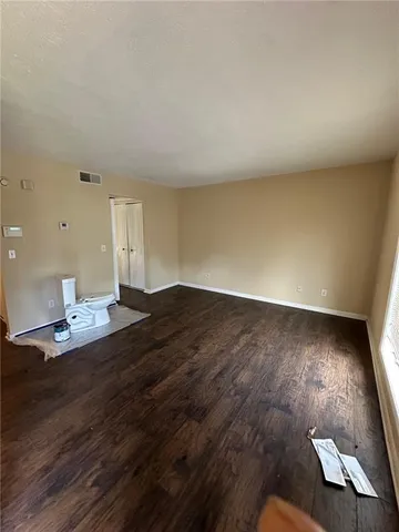 a view of empty room with wooden floor