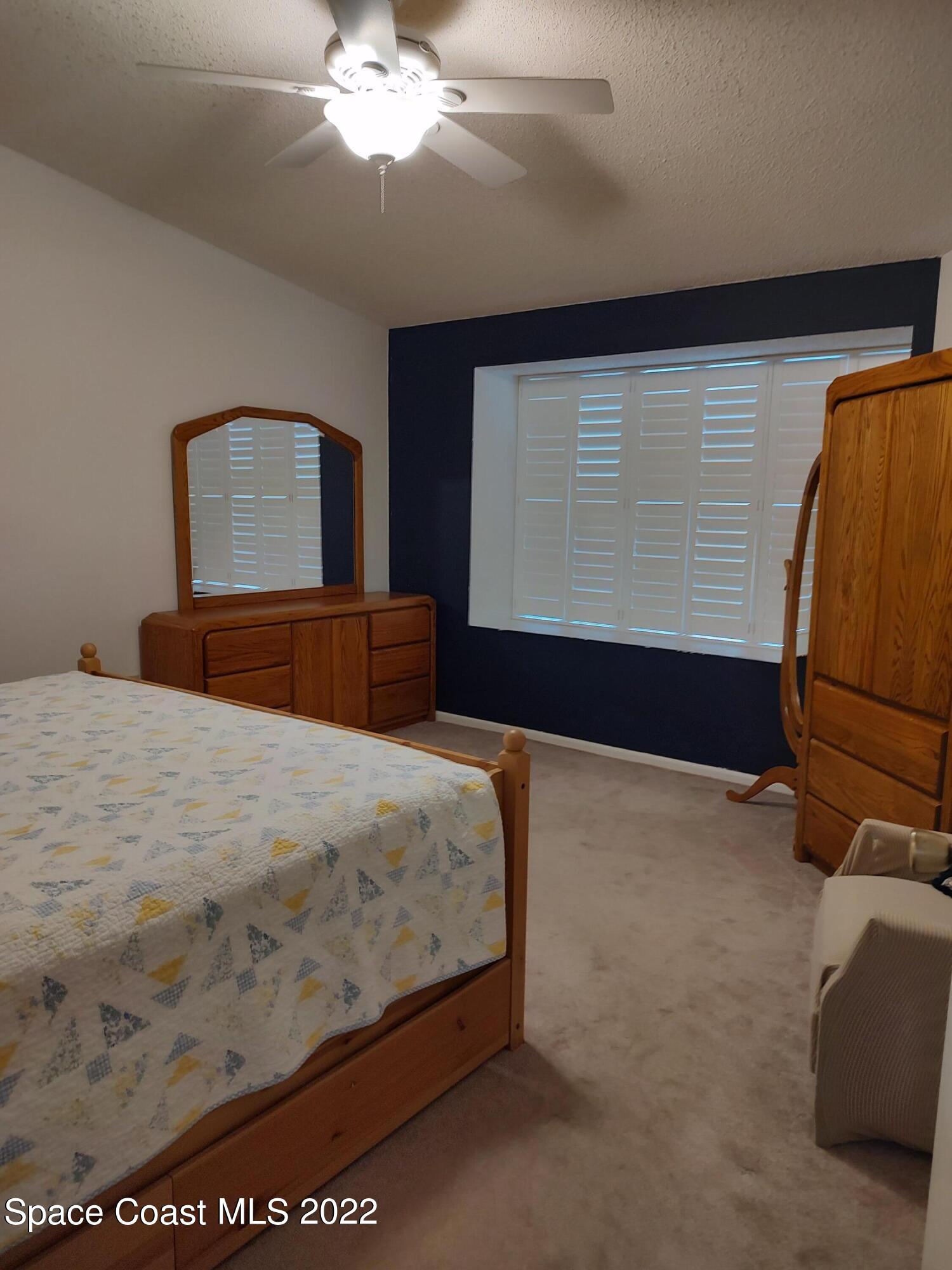 1233 Walnut Grove Way Rockledge, FL 32955 - Photo 12 of 19 a bedroom with a bed and a dresser