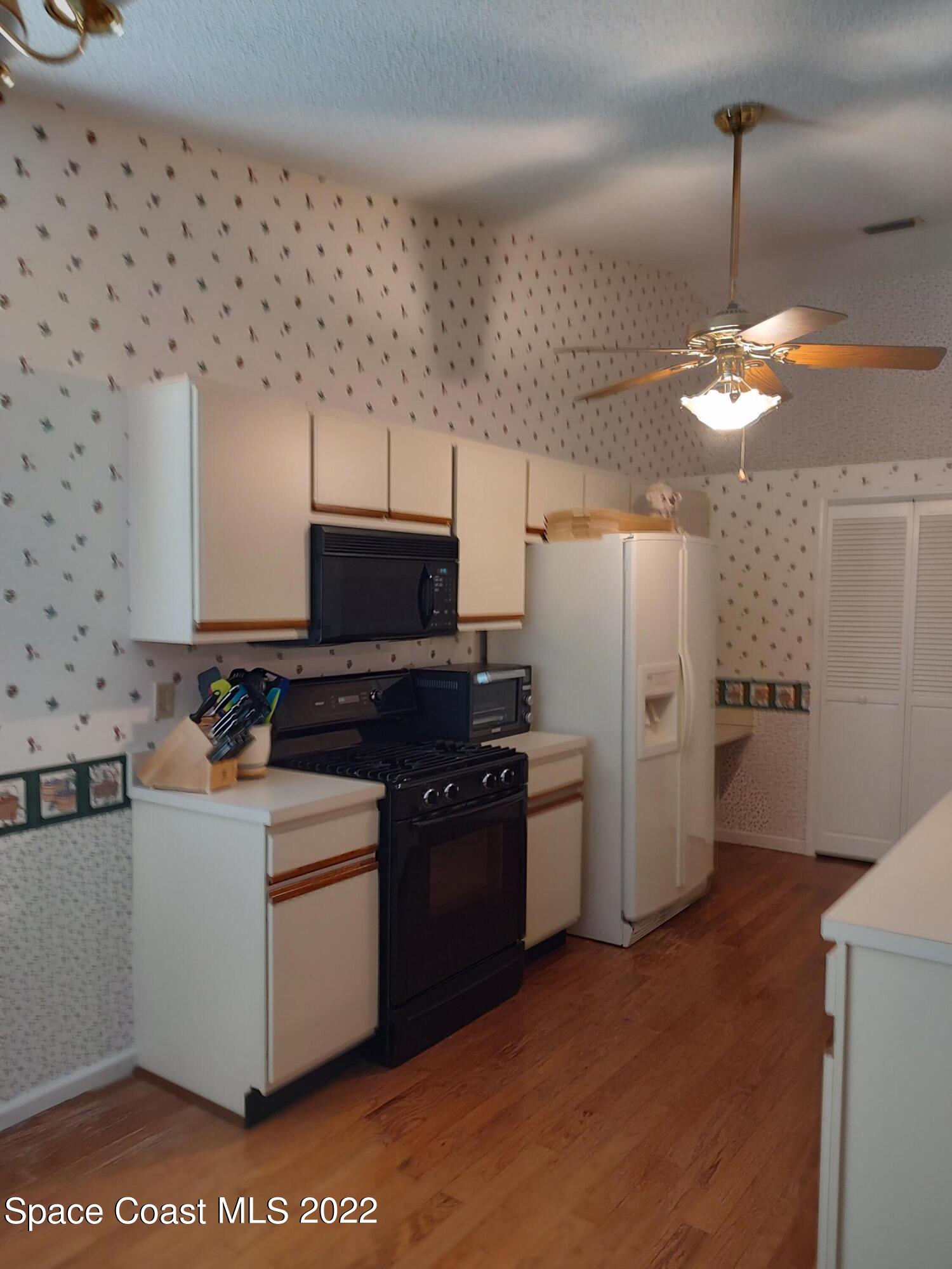 1233 Walnut Grove Way Rockledge, FL 32955 - Photo 15 of 19 a kitchen with a refrigerator and a sink