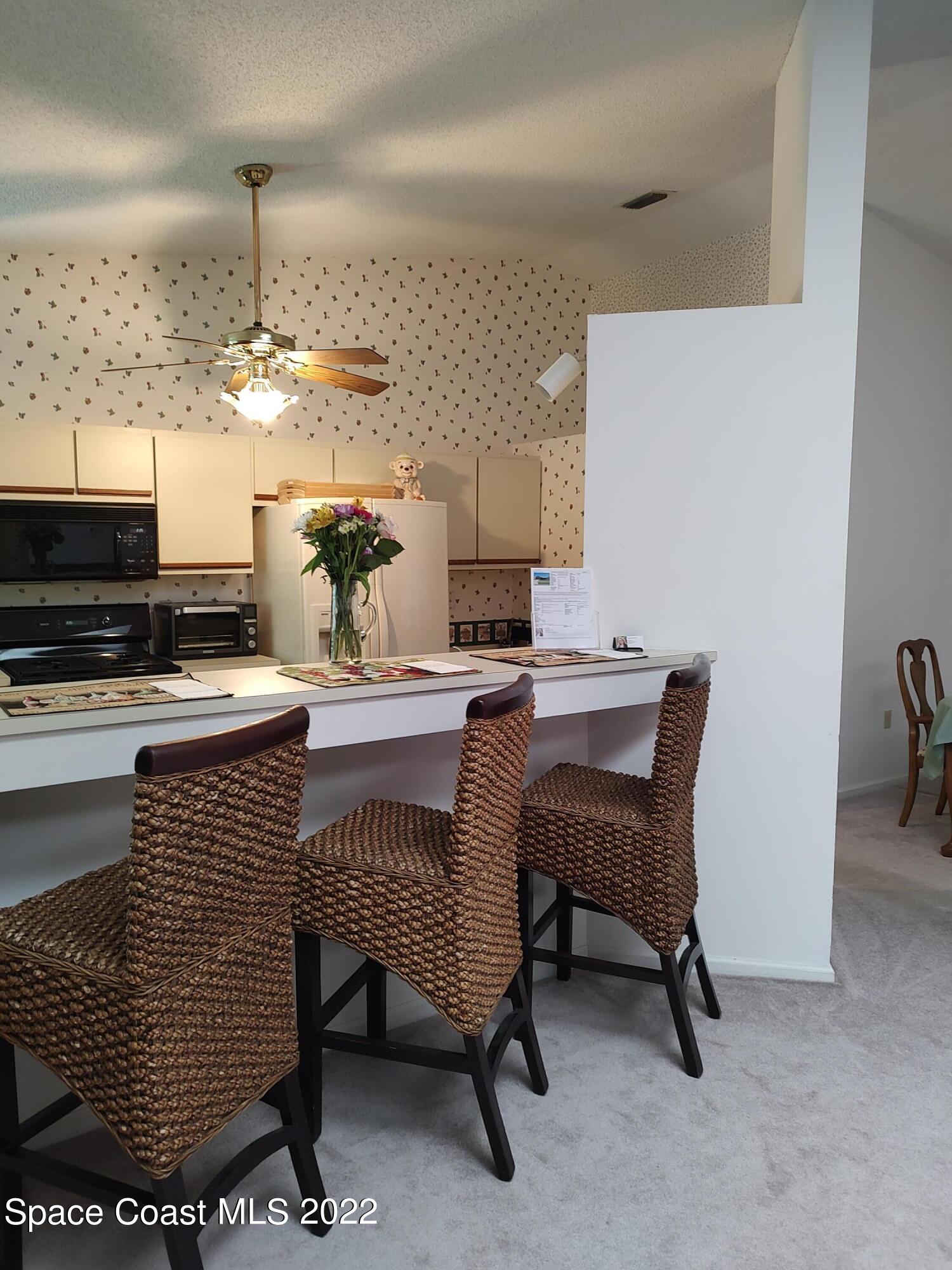 1233 Walnut Grove Way Rockledge, FL 32955 - Photo 17 of 19 a dining room with furniture and a kitchen view