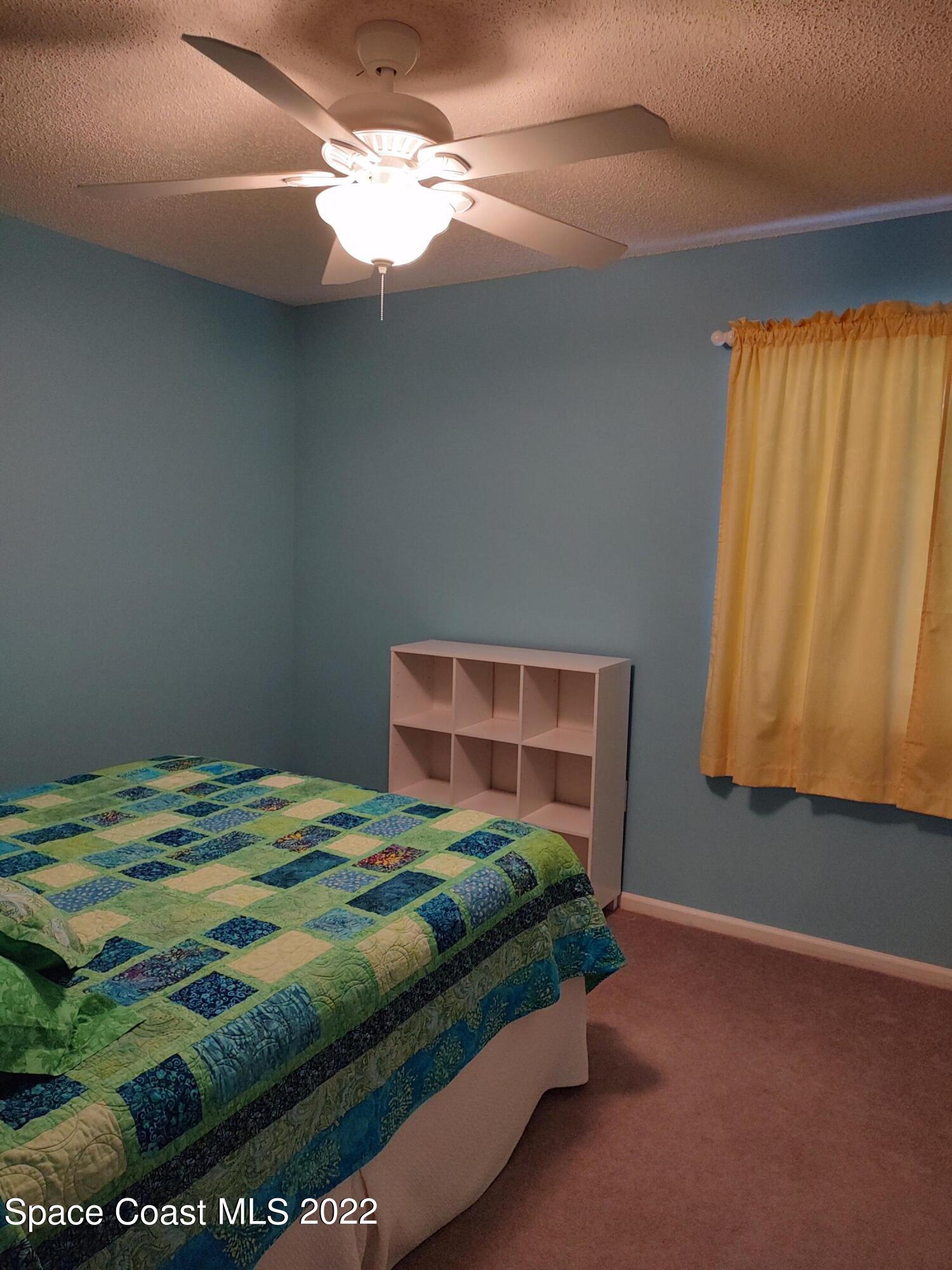 1233 Walnut Grove Way Rockledge, FL 32955 - Photo 7 of 19 a bedroom with a bed and a window