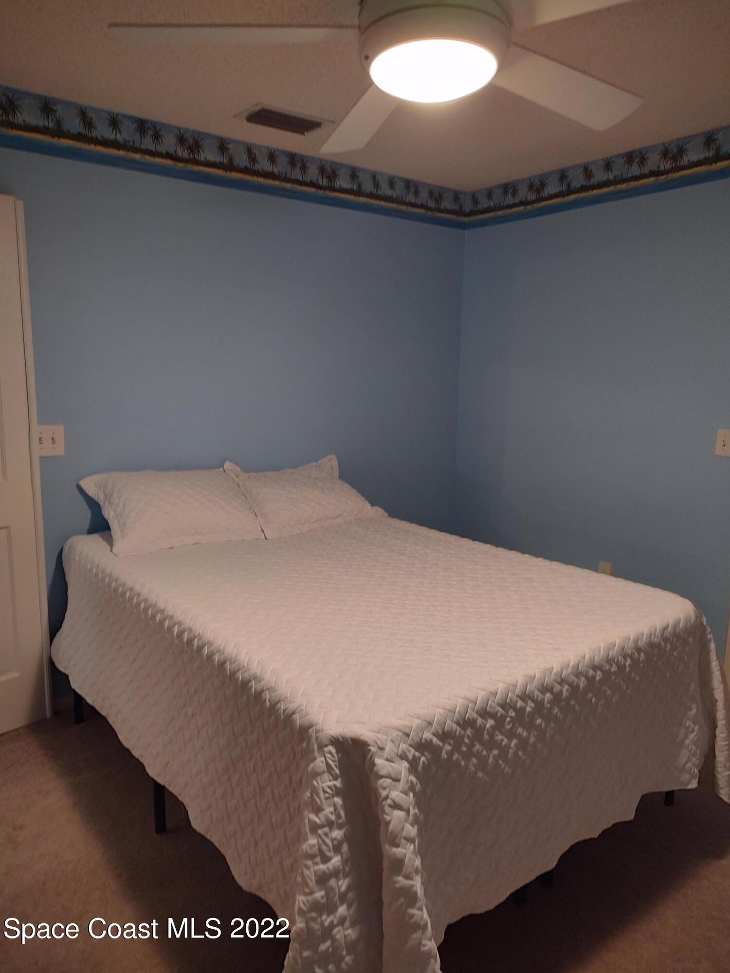 1233 Walnut Grove Way Rockledge, FL 32955 - Photo 10 of 19 a bed sitting in a bedroom next to a window