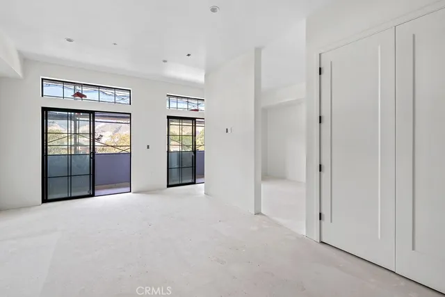 an empty room with windows and cabinet
