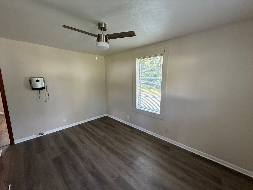 501 Houston Street Killeen, TX 76541 - Photo 4 of 11 an empty room with wooden floor ceiling fan and windows