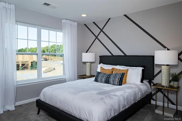 a bedroom with a bed a dresser next to a window