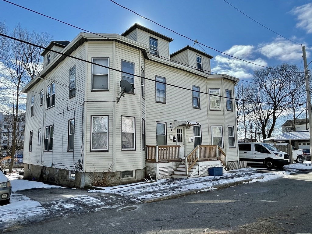 a view of a white house with large windows next to a road