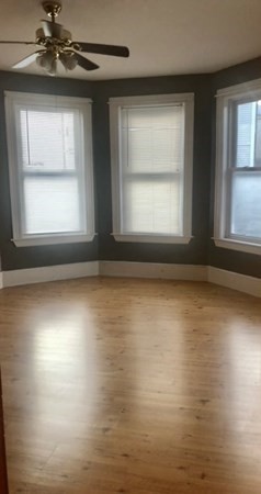 20 Bennett Street Beverly, MA 01915 - Photo 19 of 20 an empty room with wooden floor windows and fan