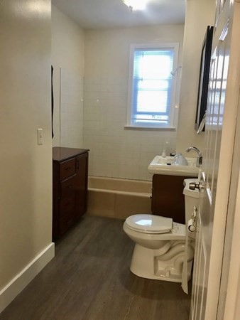 20 Bennett Street Beverly, MA 01915 - Photo 20 of 20 a white toilet sitting next to a bathroom sink and a mirror