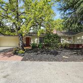 a view of a house with a tree in front of it